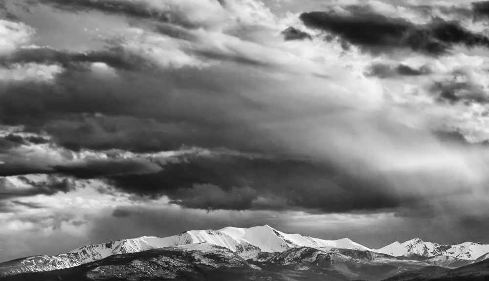 Clouds over snow-capped mountains