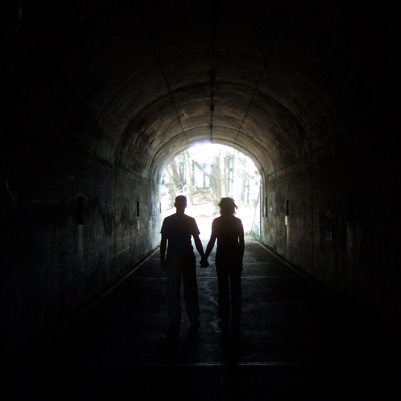 two people in dark tunnel