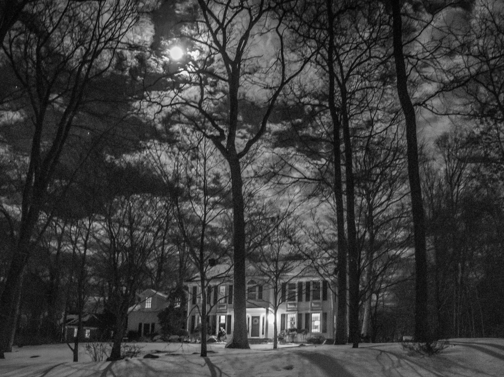 moon over snowy woods with house