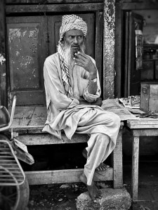 Old man sitting in alley in India
